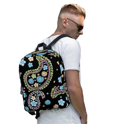 Man wearing a trendy paisley print backpack with colorful floral designs on a black background