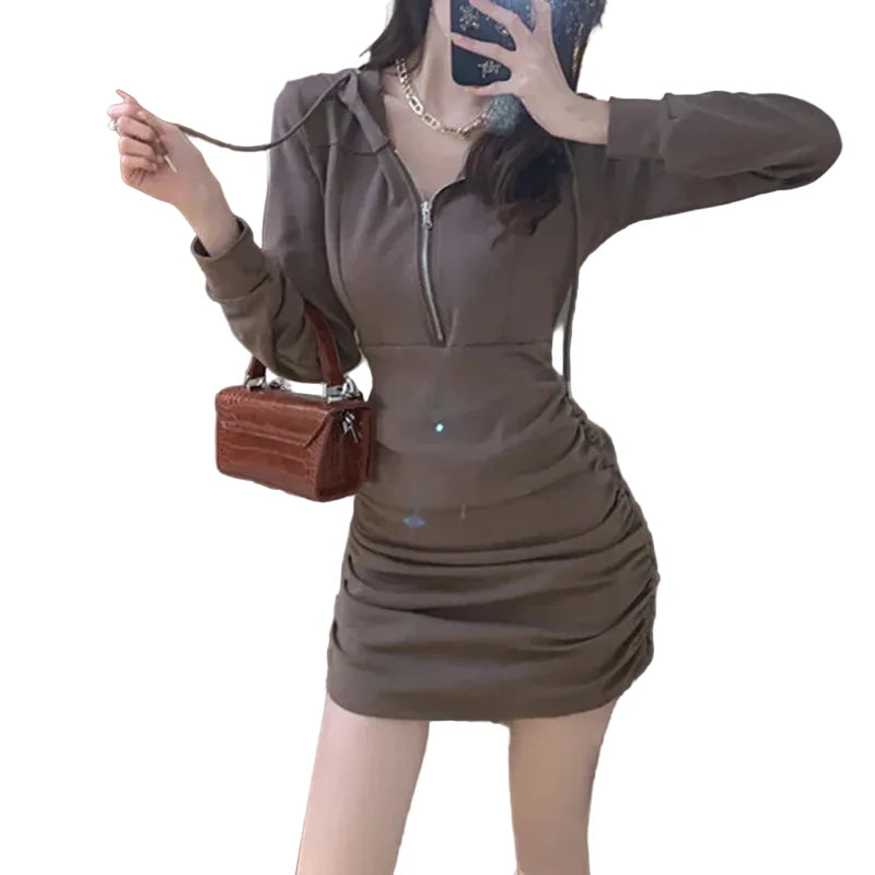 Person wearing a brown outfit with a matching handbag in an indoor setting.