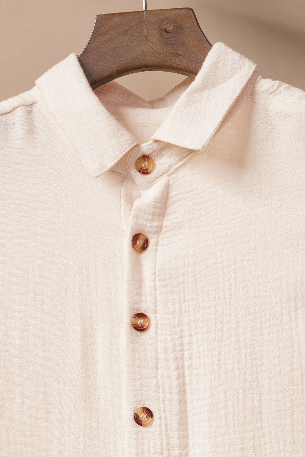 Soft beige cover-up with button details, perfect for beachwear and maxi dress layering.