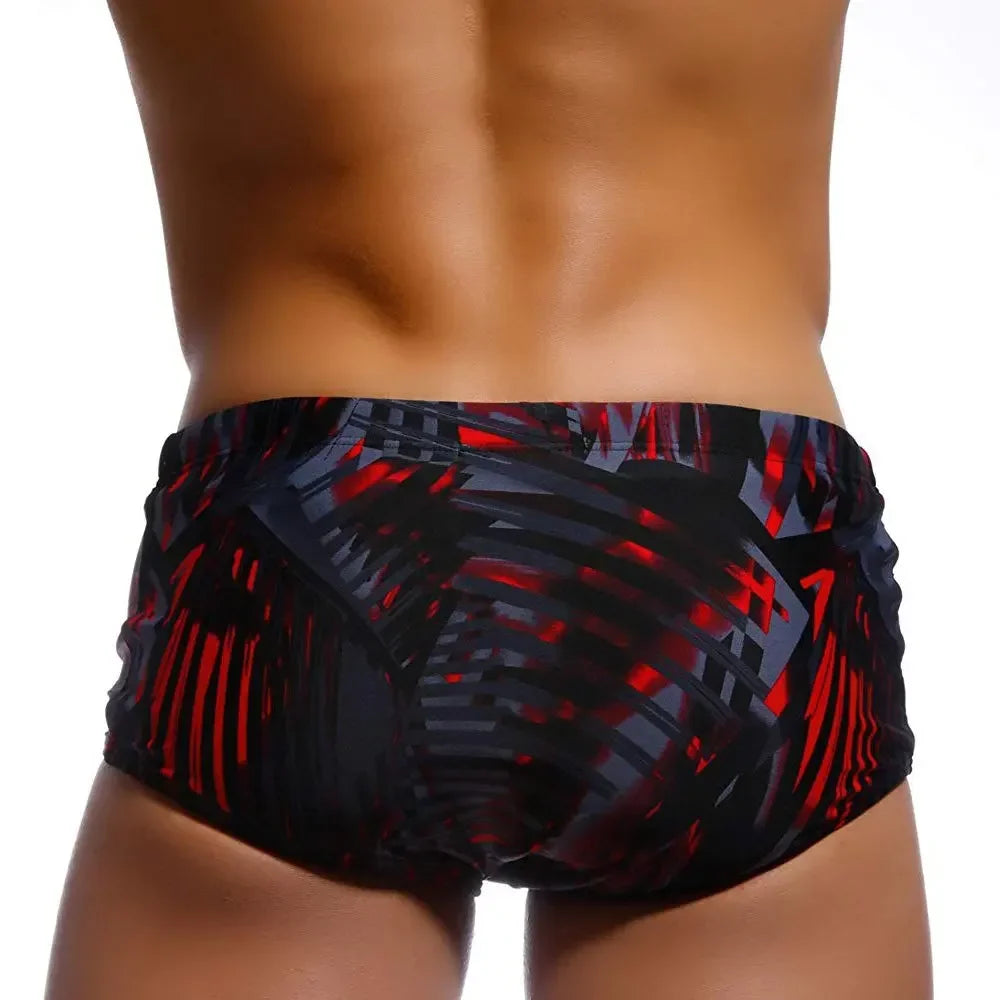 Back view of Brazilian men's swimwear featuring a bold red and black design for a stylish beach look