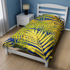 LuckeLadybug tropical palm print blanket with yellow and green leaves on blue background on white bed