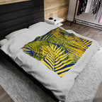 Tropical palm print blanket with green and yellow leaves design on white bedding in modern bedroom