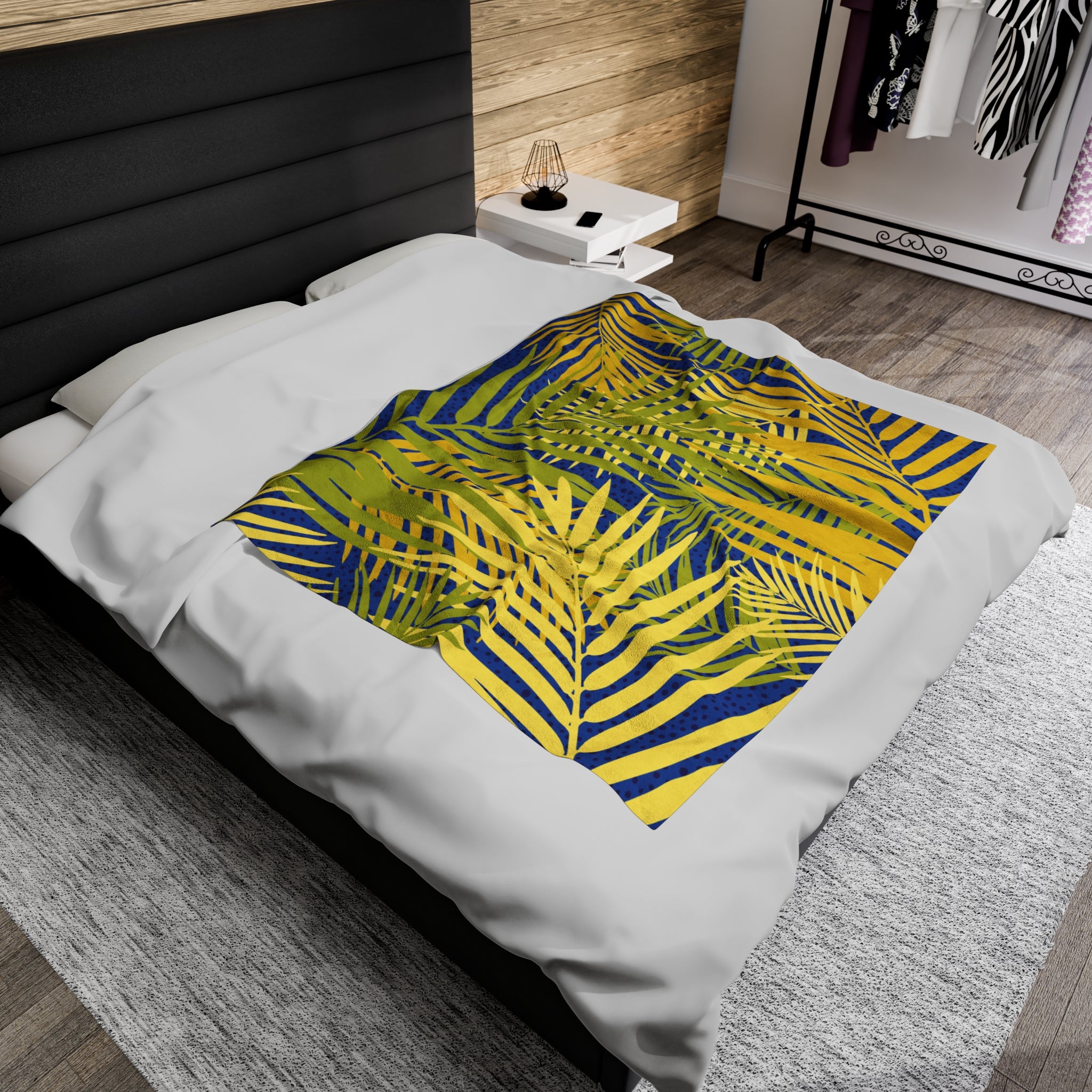 Tropical palm print blanket with green and yellow leaves design on white bedding in modern bedroom