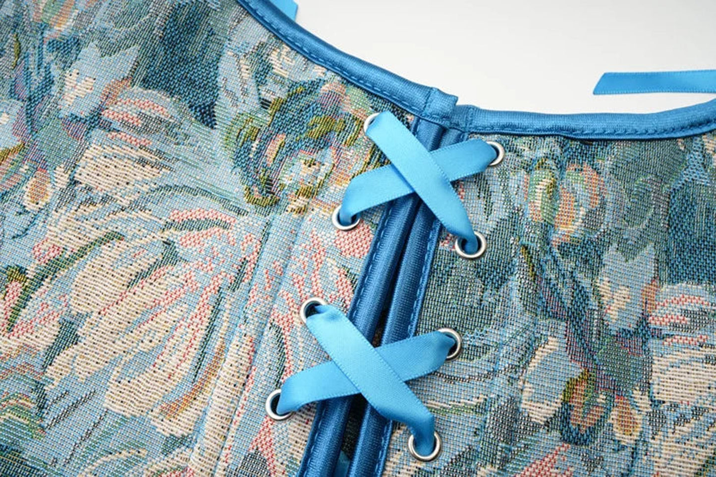 Close-up of a floral patterned Victorian corset top for women featuring blue laces and detailing