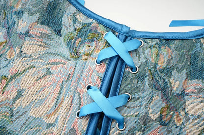 Close-up of a floral patterned Victorian corset top for women featuring blue laces and detailing