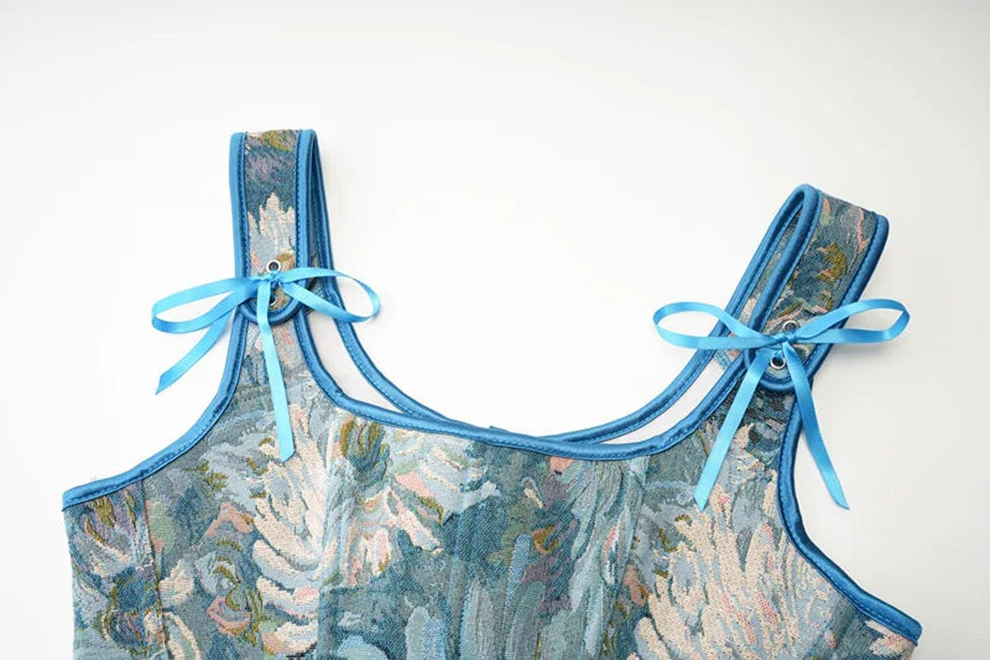 Close-up of blue floral Victorian corset top for women with ribbon straps by LuckeLadybug LLC