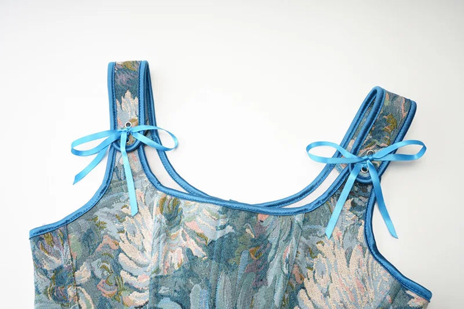 Close-up of blue floral Victorian corset top for women with ribbon straps by LuckeLadybug LLC