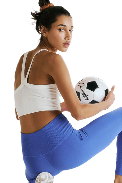 LuckeLadybug white ribbed cropped cami top worn by woman holding a soccer ball in activewear