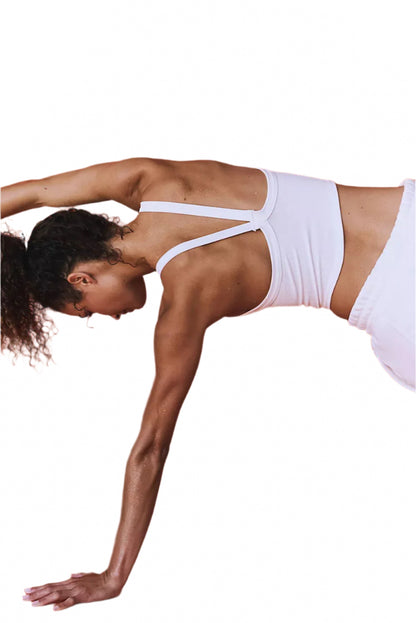 LuckeLadybug white ribbed cropped cami top worn by woman in active pose against orange background