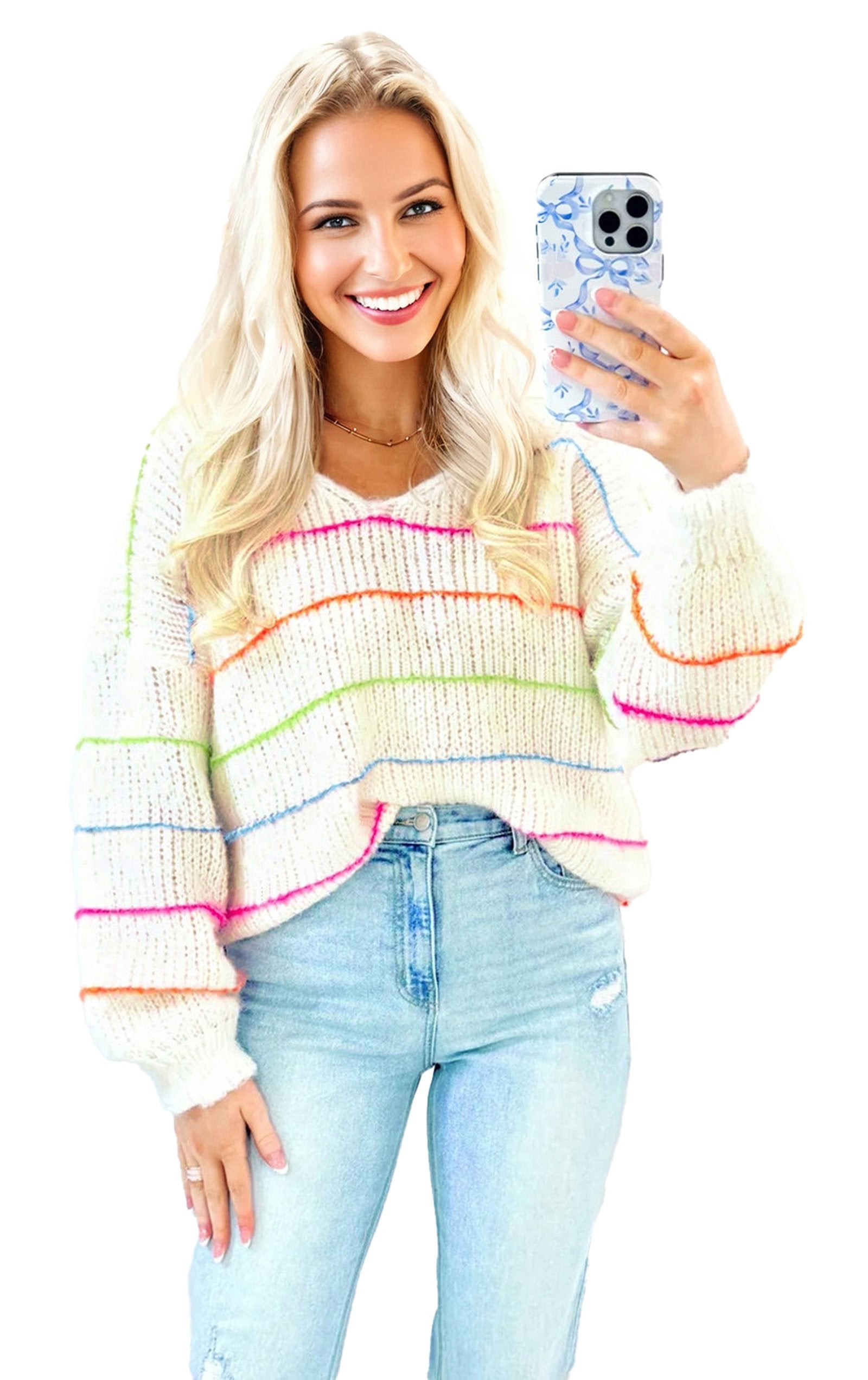 Model wearing a white v neck striped sweater with colorful stripes paired with light blue jeans