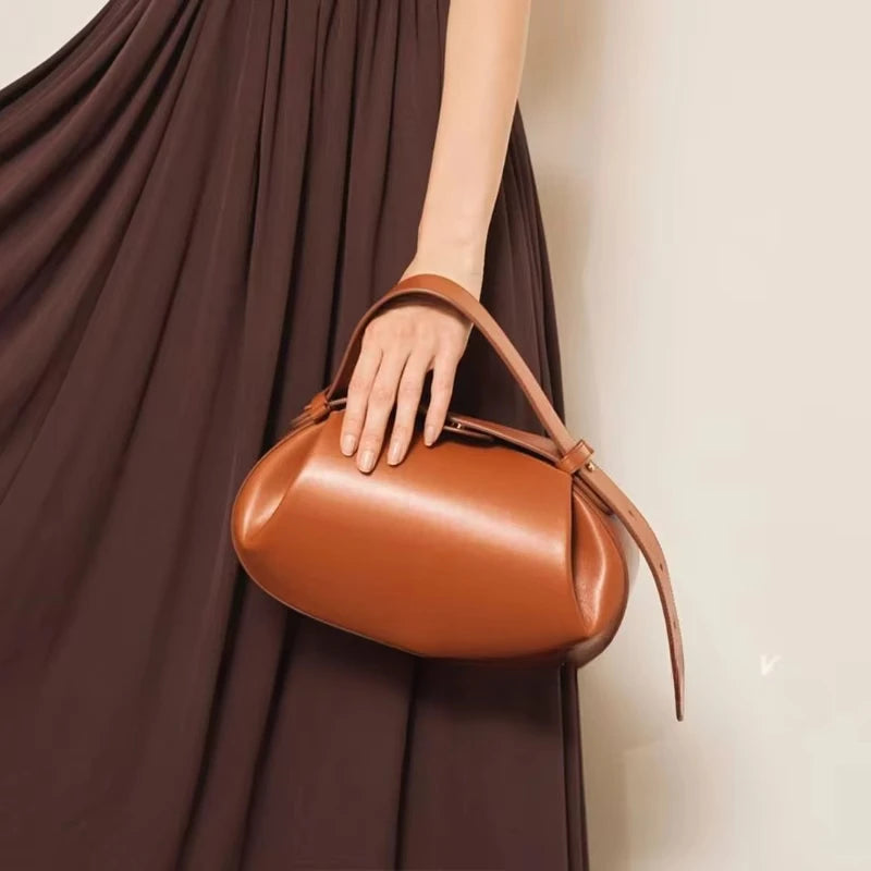 Stylish women's crossbody round bag in brown with a chic design and comfortable handle