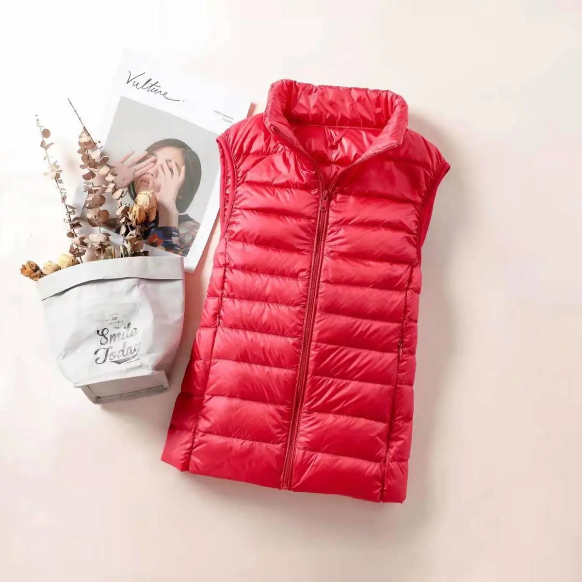 Bright red women's lightweight down vest with a zip front and sleeveless design for warmth