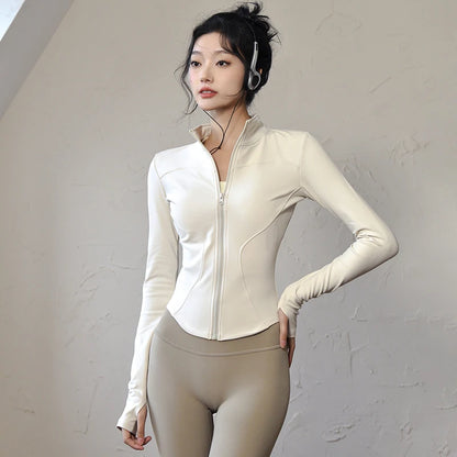 Women's long sleeve sports jacket in cream color with a fitted design for active wear