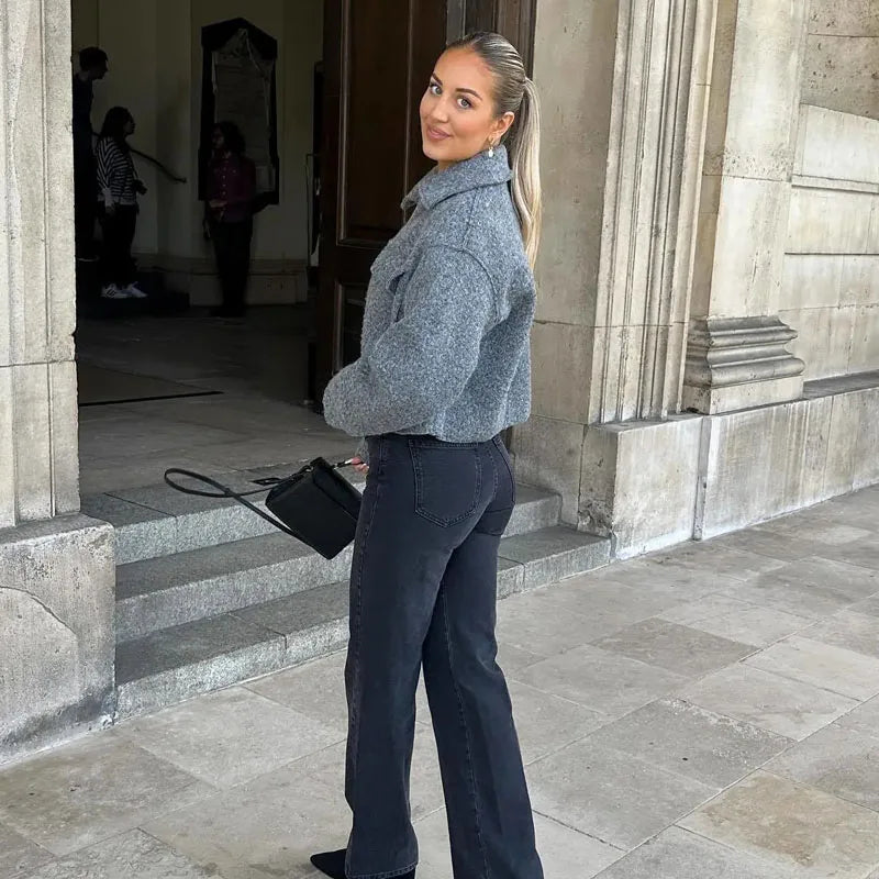Stylish woman wearing a women's tweed cropped jacket with black pants and a small handbag