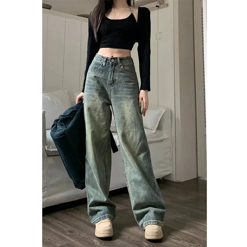 Y2K baggy jeans women in faded green denim, styled with a black crop top for a trendy look